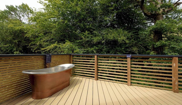 Riverside lodge with spacious decking, Ninja BBQ, Wi-Fi, Netflix-ready TV, EV charging and an outdoor copper bath and shower for a wellness experience in nature. Up to three well-behaved dogs are welcome in selected lodges.